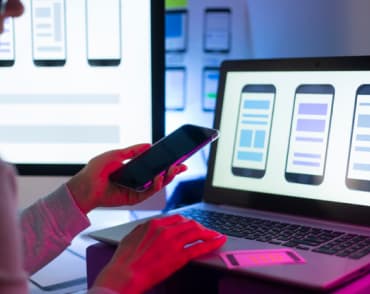smartphone-in-the-hand-in-front-of-laptop-with-interface-mobile-phones